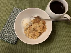 apple crisp plated with vanilla ice cream and coffee